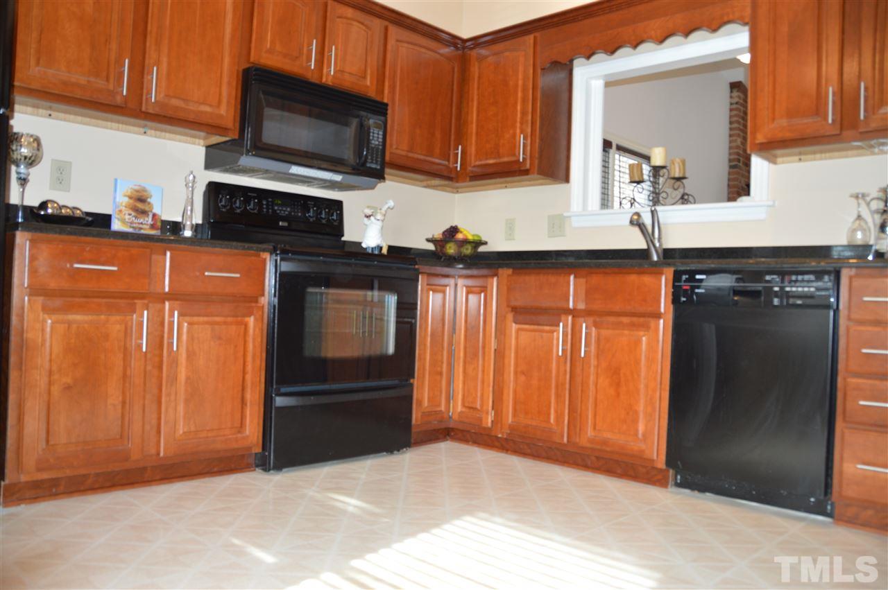 1514 Ferncliff Circle Raleigh, NC 27609 - Photo 3 of 18 a kitchen with granite countertop wooden cabinets and a stove top oven