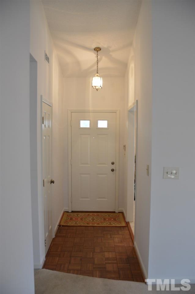 1514 Ferncliff Circle Raleigh, NC 27609 - Photo 5 of 18 a view of a hallway with wooden floor and a bathroom