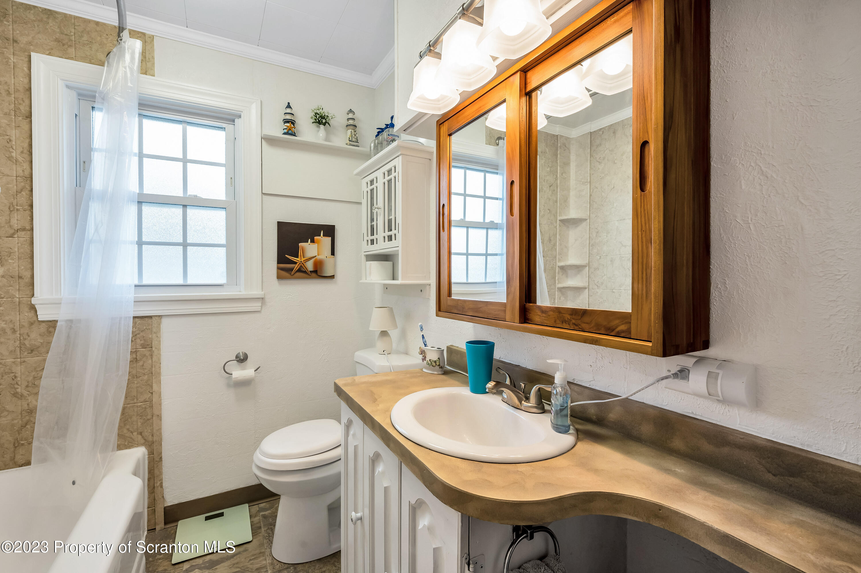 709 Meade Street Throop, PA 18512 - Photo 14 of 37 a bathroom with a sink a toilet and a mirror