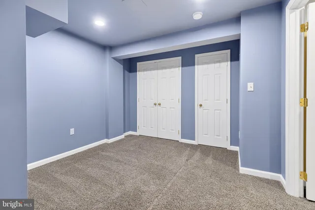 an empty room with windows and cabinet