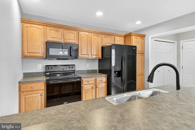 a kitchen with stainless steel appliances granite countertop a refrigerator stove microwave and sink