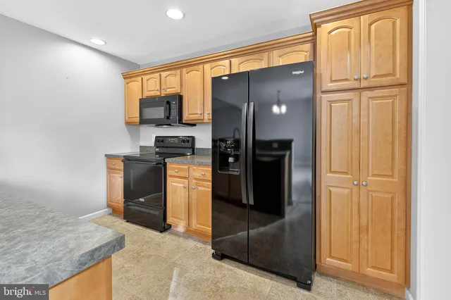 a kitchen with stainless steel appliances granite countertop a refrigerator and a sink