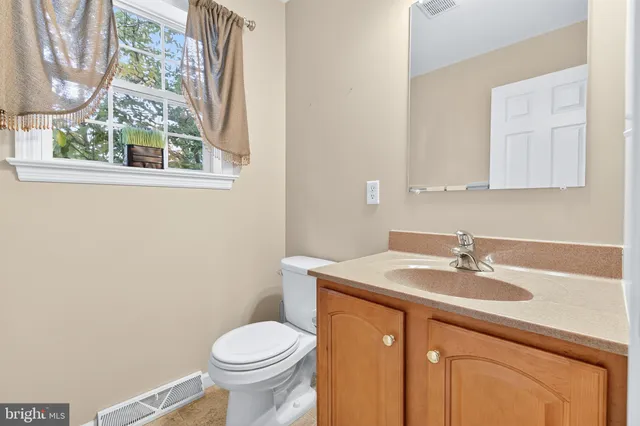 a view of an empty room with stairs and a window