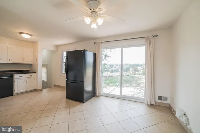 a kitchen with a refrigerator a stove top oven a sink and a window