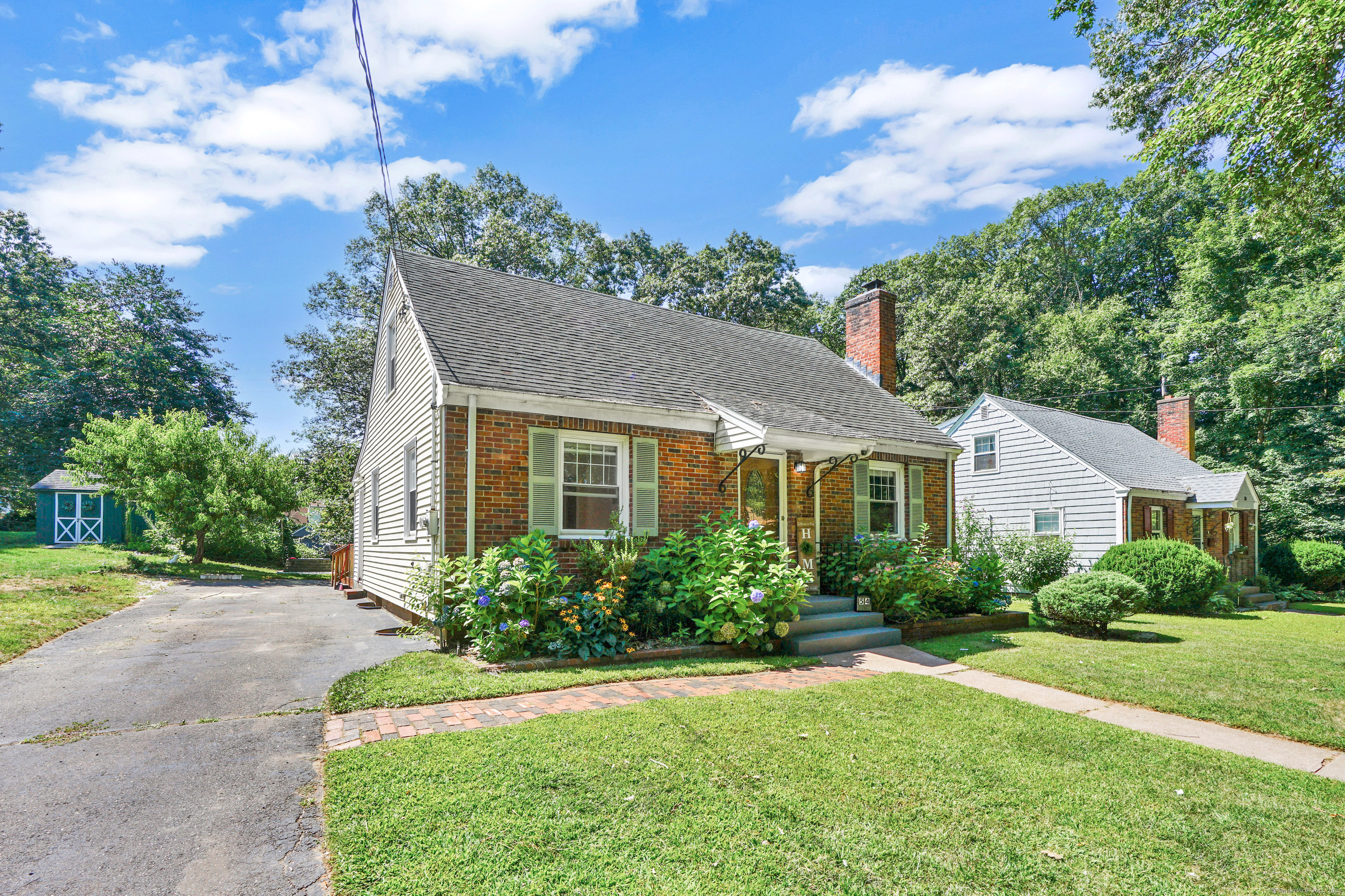a front view of a house with a yard and trees