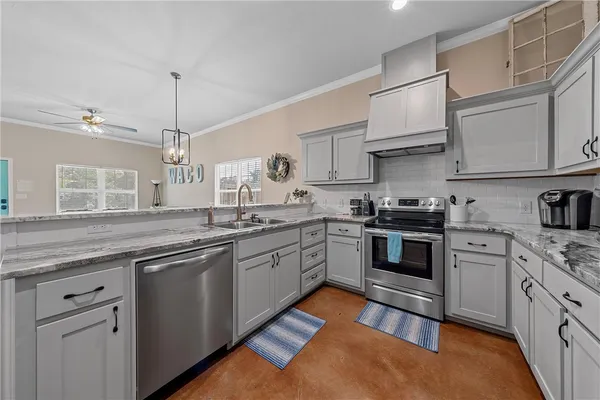 a kitchen with stainless steel appliances granite countertop a sink and cabinets