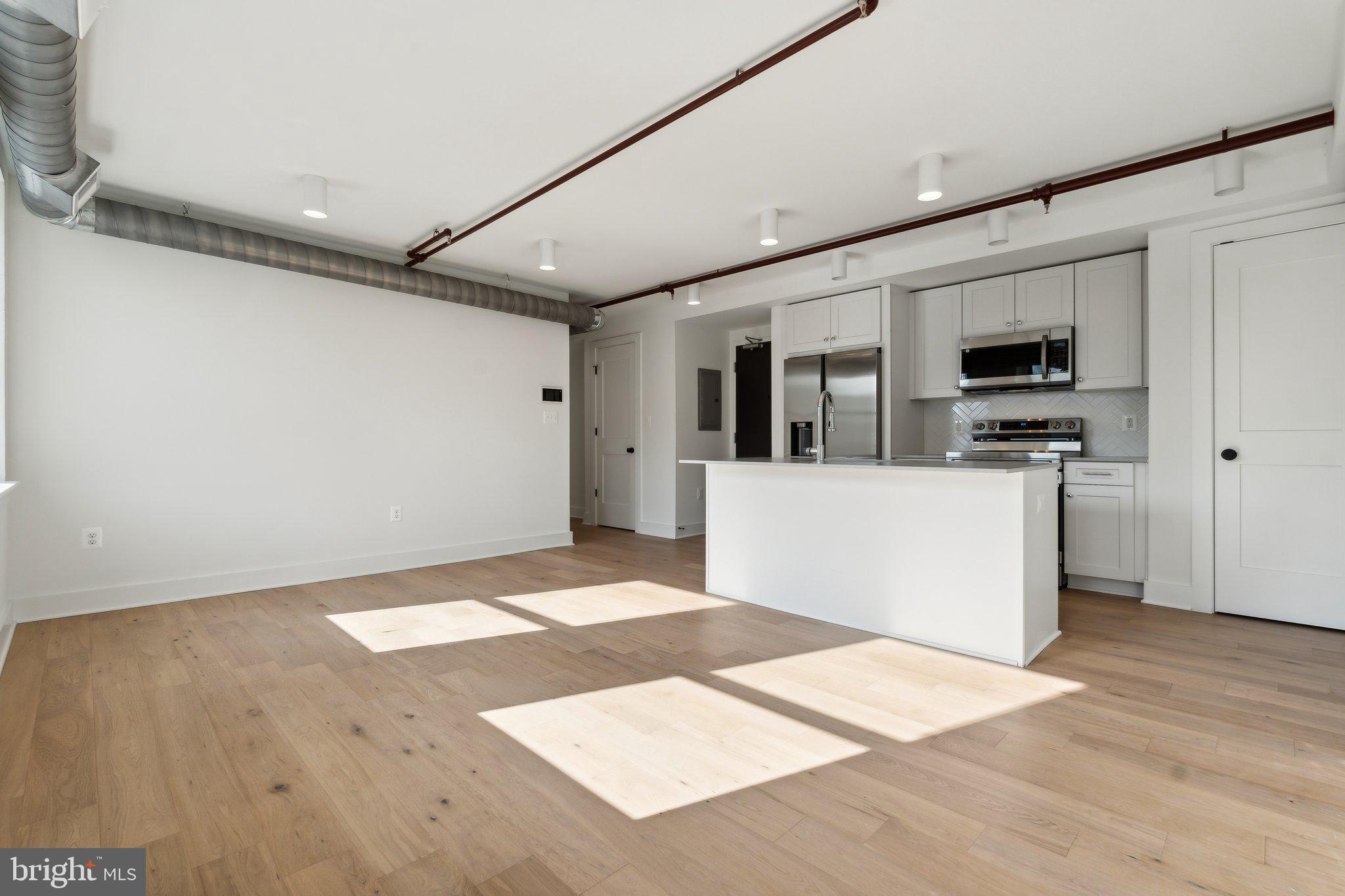 901 King Street, Unit 203 Alexandria, VA 22314 - Photo 19 of 52 a view of a kitchen with wooden floor and electronic appliances