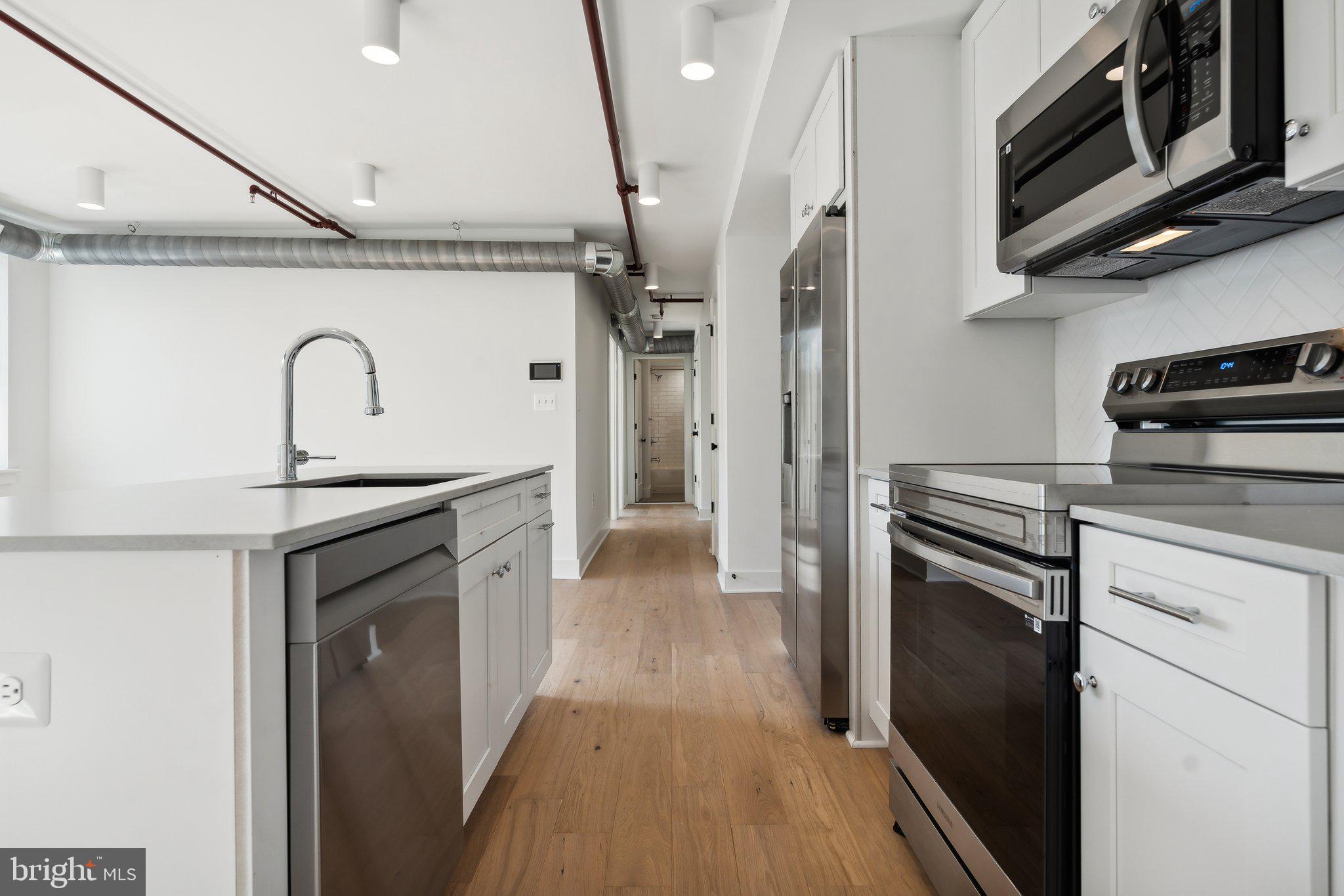 901 King Street, Unit 203 Alexandria, VA 22314 - Photo 8 of 52 a kitchen with stainless steel appliances granite countertop a stove a refrigerator and a microwave