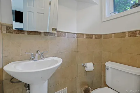 a bathroom with a sink a toilet and a mirror