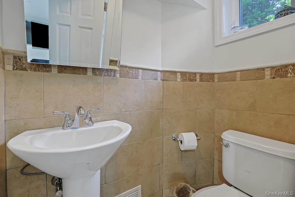 305 Stratton Road New Rochelle, NY 10804 - Photo 27 of 32 a bathroom with a sink a toilet and a mirror