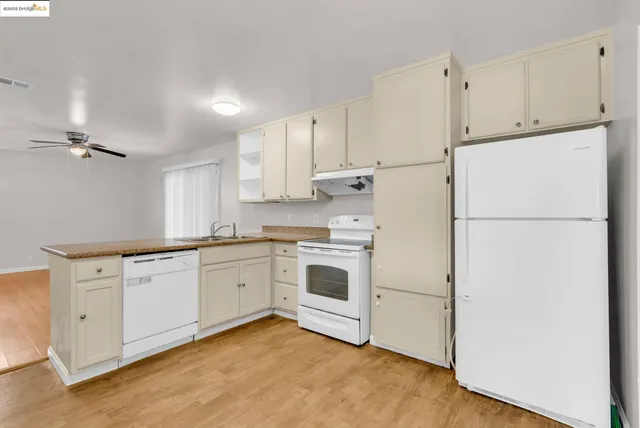 a kitchen with granite countertop white cabinets and white appliances