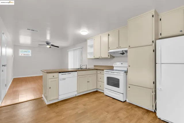 a kitchen with granite countertop white cabinets and white appliances