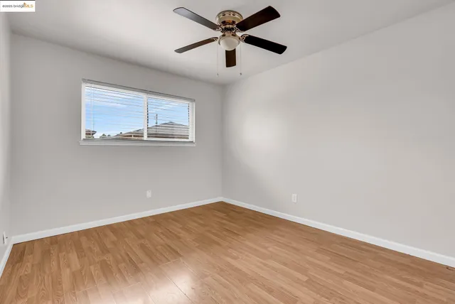 a view of a big room with wooden floor and a chandelier fan