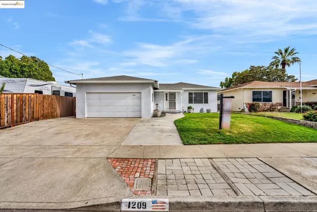 a front view of a house with a yard and potted plants