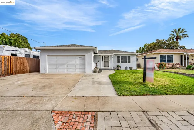 a front view of a house with a yard and potted plants