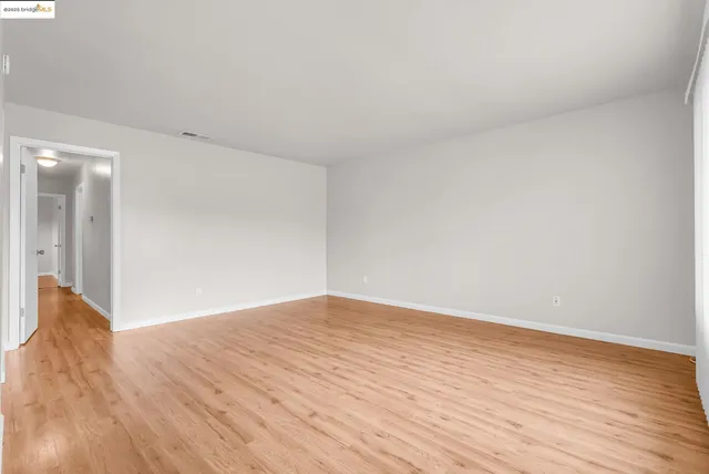 a view of an empty room and wooden floor