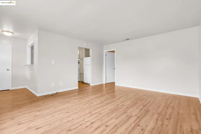 a view of an empty room with wooden floor
