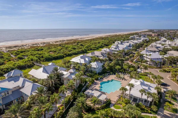 a front view of a building with a yard and trees