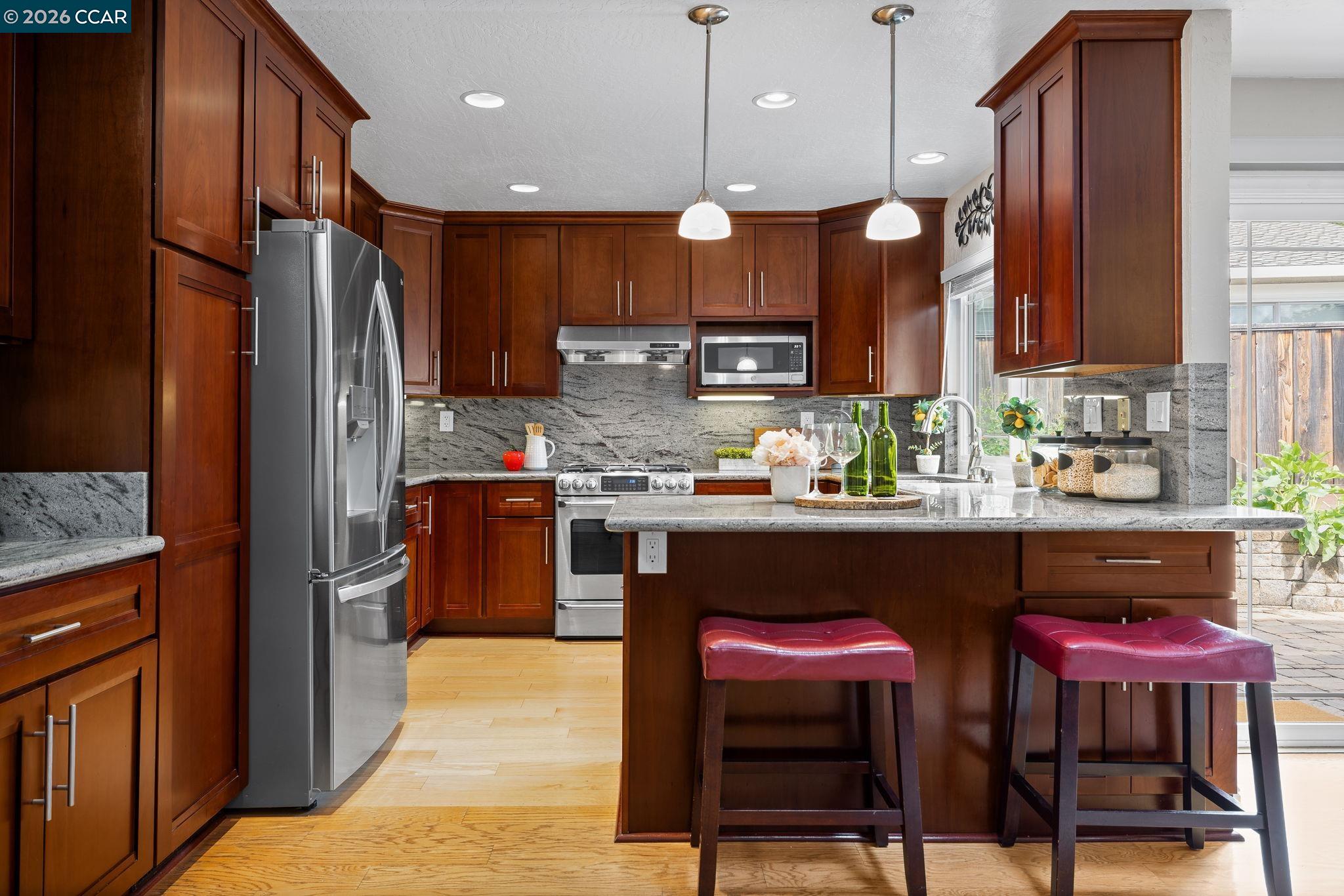 2095 Robb Road Walnut Creek, CA 94596 - Photo 8 of 26 a kitchen with stainless steel appliances a refrigerator a stove a sink and chairs