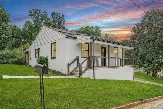a view of a house with backyard and a tree