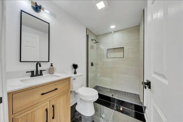 a bathroom with a toilet sink a mirror and vanity