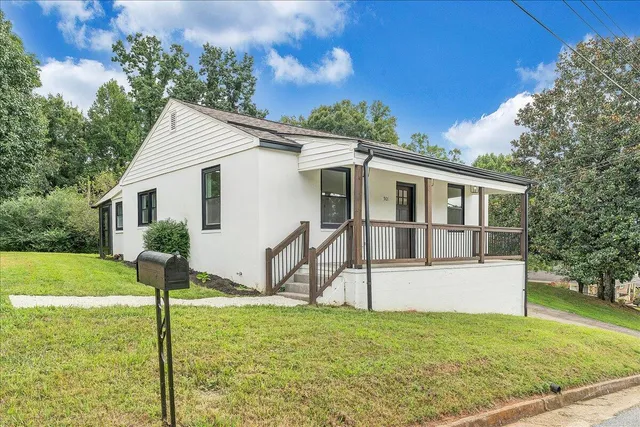 a view of a house with backyard and trees