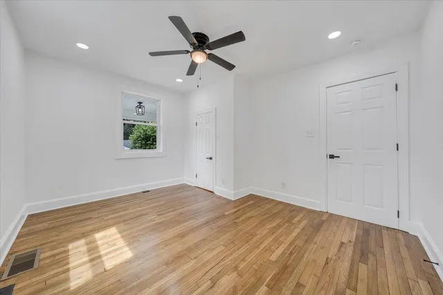 a view of a big room with wooden floor and windows