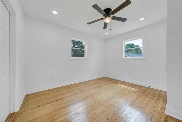 an empty room with a window and a ceiling fan