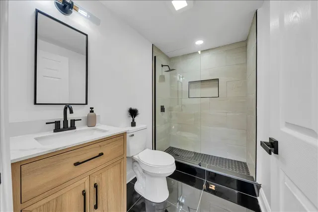 a bathroom with a toilet sink a mirror and shower