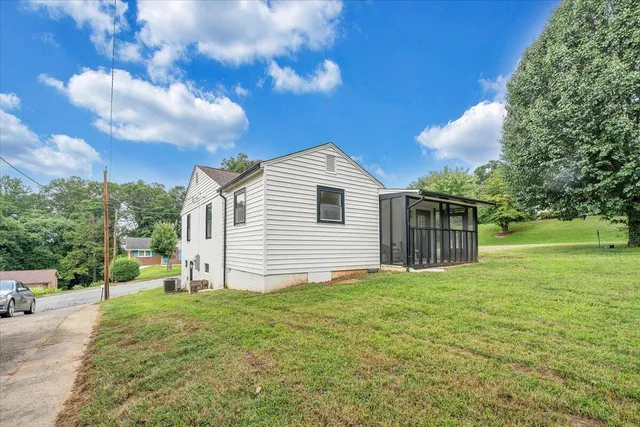 a view of a house with backyard and a tree