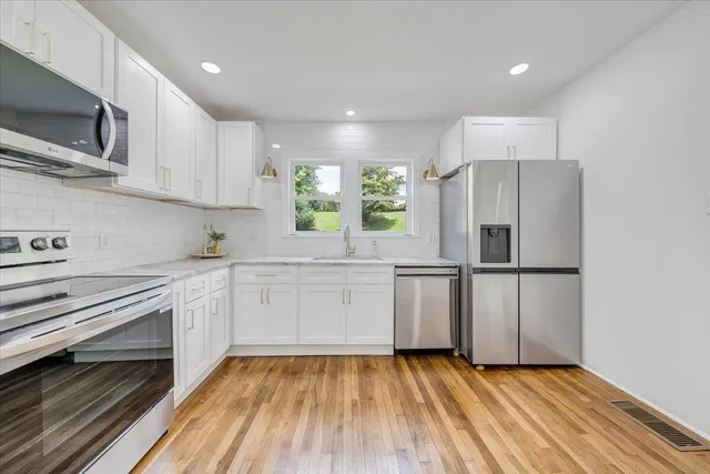 a kitchen with a refrigerator and a stove top oven