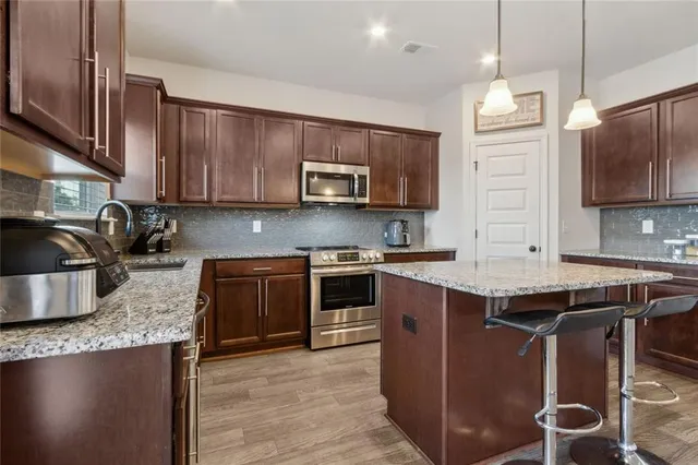 a kitchen with stainless steel appliances granite countertop a stove sink microwave and cabinets
