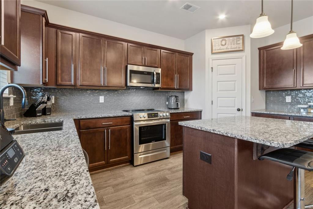 1130 Lyndhurst Lane Bethlehem, GA 30620 - Photo 23 of 46 a kitchen with stainless steel appliances granite countertop a sink stove and microwave