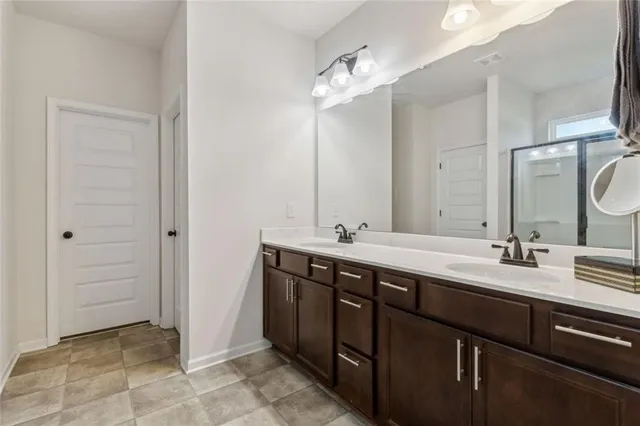 a spacious bathroom with a double vanity sink a mirror and a bathtub