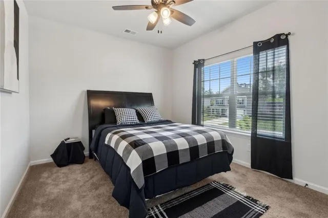 a bedroom with a bed and a flat tv screen on the dresser