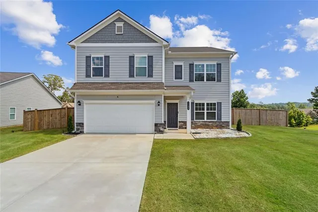 a front view of a house with a yard and garage