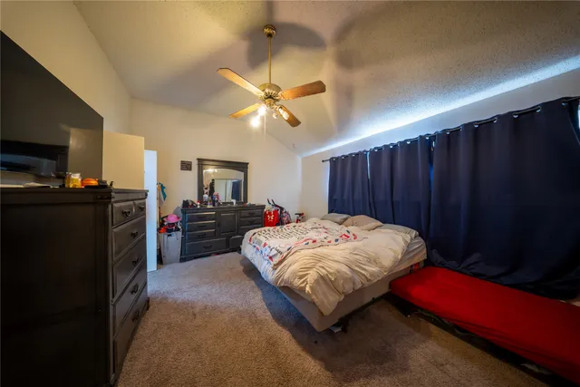 a bed sitting in a bedroom next to a window with pc on the wall