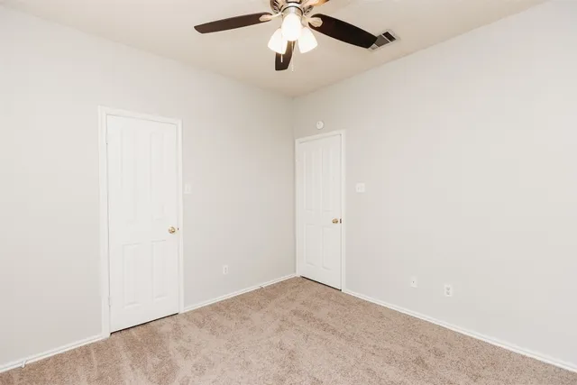 an empty room with chandelier fan