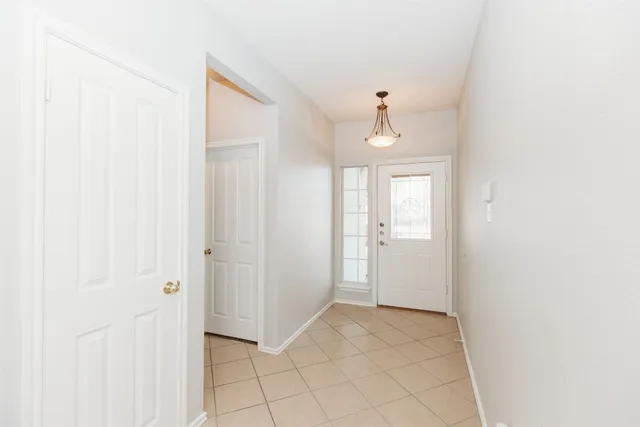a view of a hallway with a chandelier fan