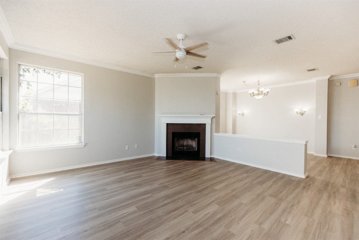 1506 Freestone Drive Pflugerville, TX 78660 - Photo 6 of 20 a view of an empty room with wooden floor fireplace and a window