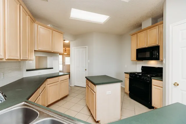 a kitchen with granite countertop a sink and a stove top oven