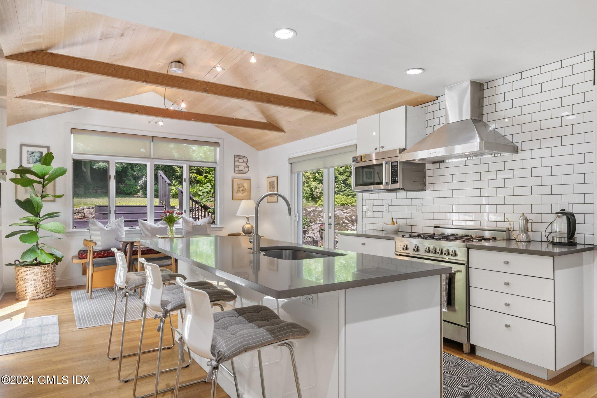 300 Orchard Street Greenwich, CT 06830 - Photo 14 of 40 a kitchen with stainless steel appliances granite countertop a stove a sink a oven a dining table and chairs