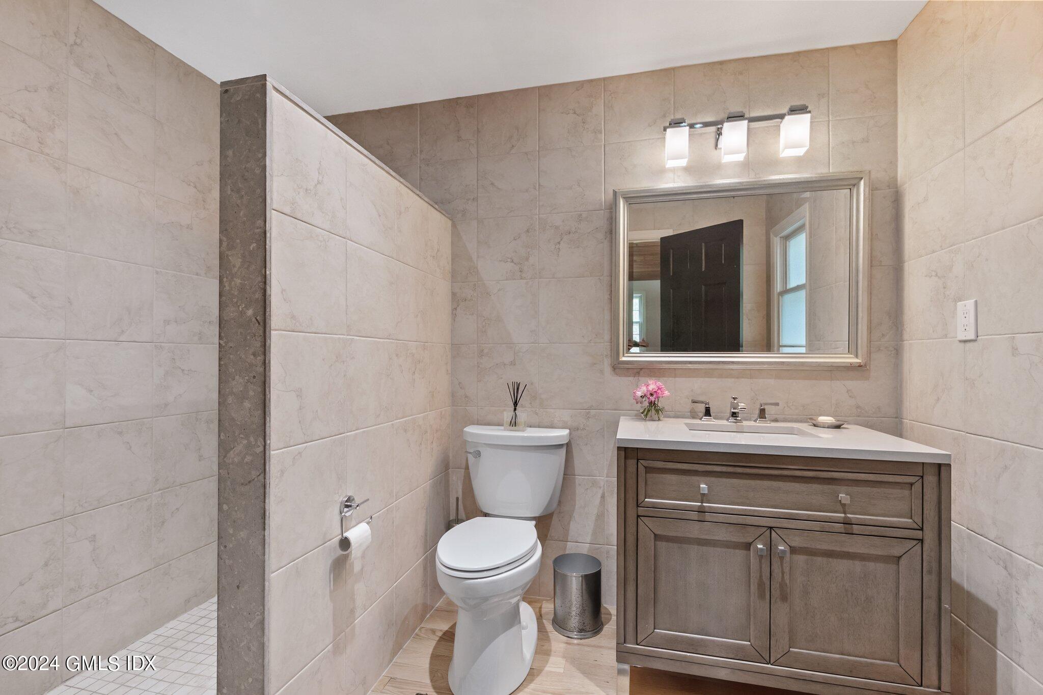 300 Orchard Street Greenwich, CT 06830 - Photo 24 of 40 a bathroom with a toilet sink and mirror