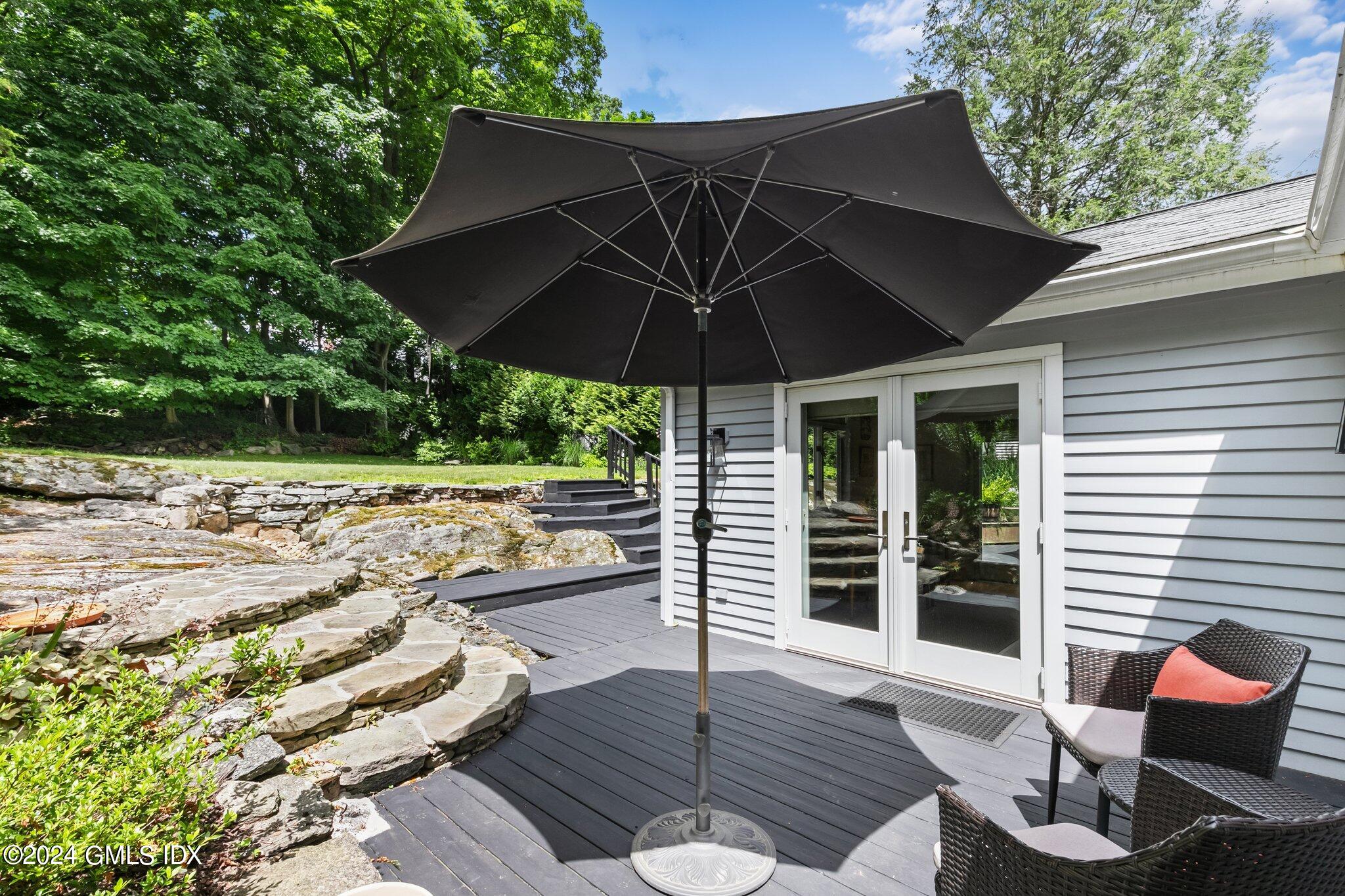 300 Orchard Street Greenwich, CT 06830 - Photo 34 of 40 a view of a patio with table and chairs under an umbrella