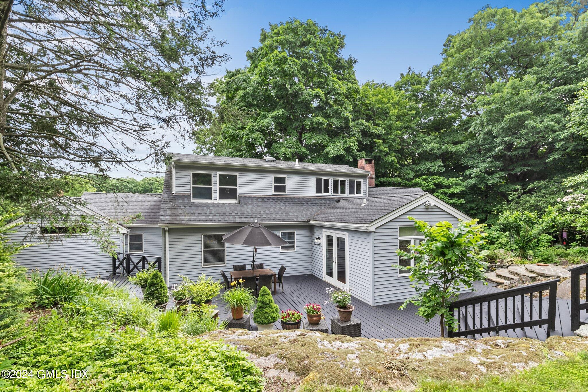 300 Orchard Street Greenwich, CT 06830 - Photo 35 of 40 a front view of a house with a yard and potted plants