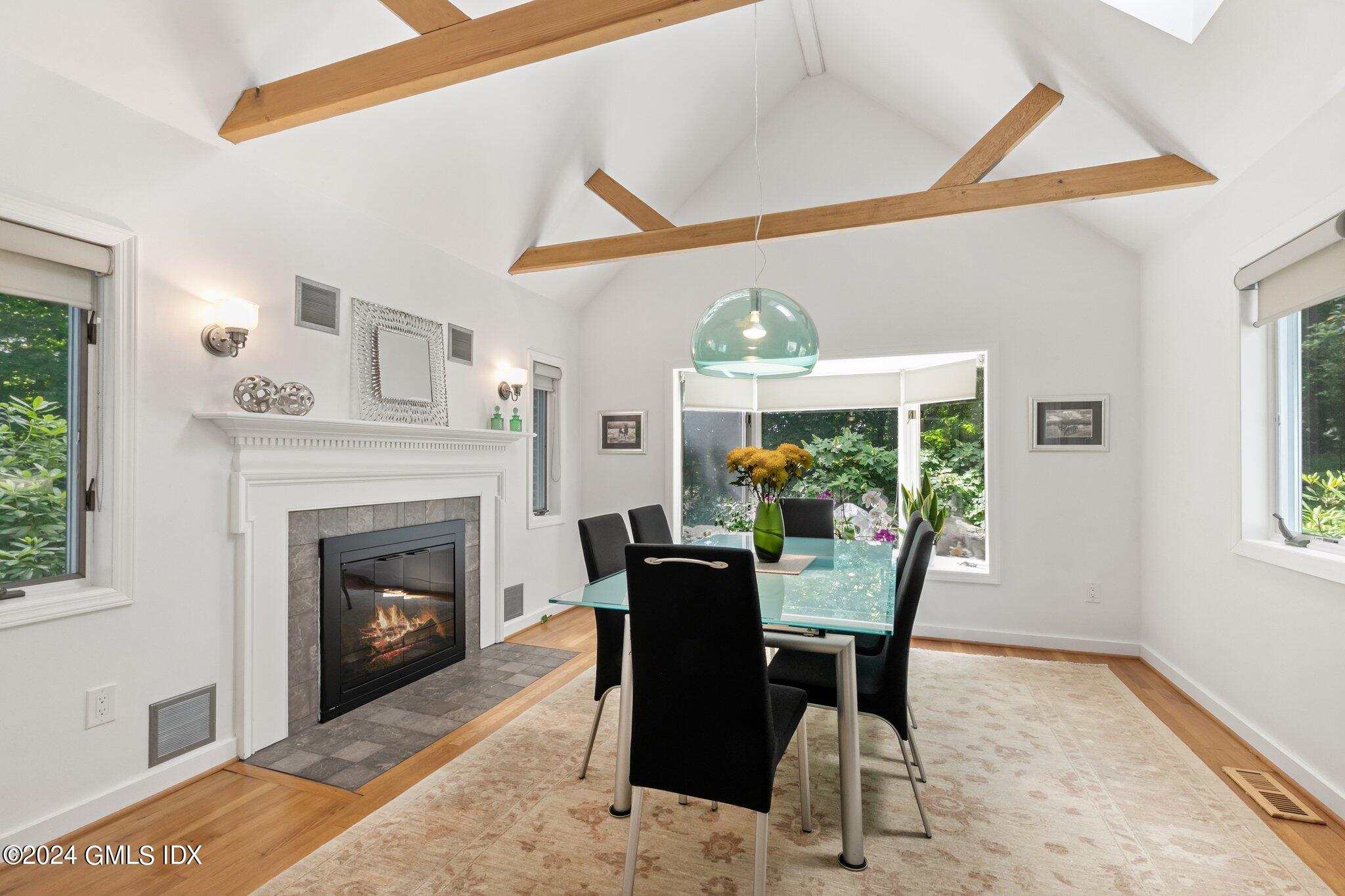 300 Orchard Street Greenwich, CT 06830 - Photo 10 of 40 a dining room with furniture a fireplace and a large window