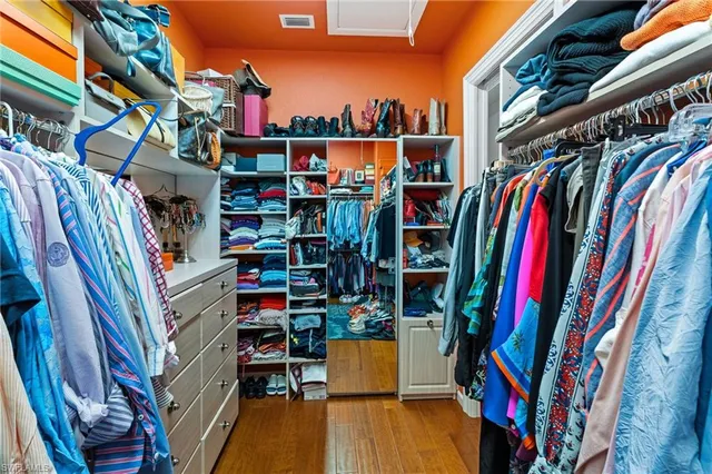 a view of walk in closet with clothes and shoes
