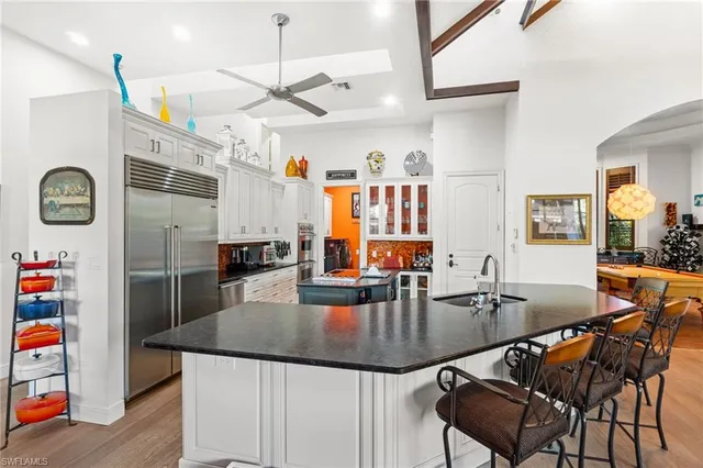 a dining room with stainless steel appliances granite countertop a dining table and chairs with wooden floor