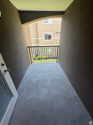 909 South Main Street, Unit F Layton, UT 84041 - Photo 14 of 20 Private balcony featuring textured concrete flooring, wrought iron railing, and stucco walls