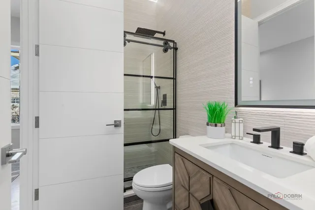 a bathroom with a granite countertop sink toilet and shower